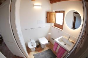 a bathroom with a sink and a toilet and a mirror at La Casa del mandarino di Borgo Carbone in Locri