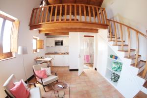a living room with a staircase and a kitchen at La Casa del mandarino di Borgo Carbone in Locri
