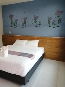 a bedroom with a bed with flowers on the wall at เคียงภูวิลล่า in Sangkhom