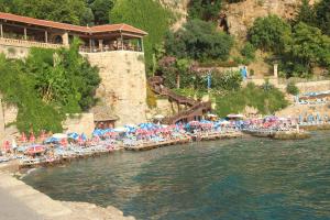Kosa boutique hotel في أنطاليا: شاطئ فيه كراسي ومظلات في الماء