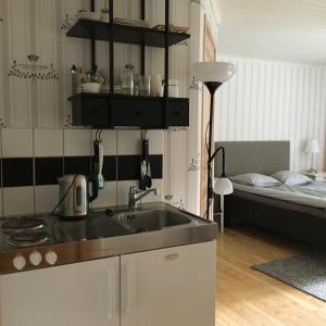 een keuken met een wastafel en een bed in een kamer bij Kvarnen i Borgvik in Borgvik