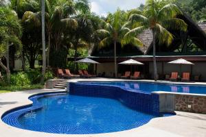 a swimming pool with palm trees and a resort at Paradise Sun Hotel Seychelles in Baie Sainte Anne