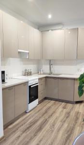 una cocina con armarios blancos y electrodomésticos blancos en Просторные светлые апартаменты на берегу моря, en Fontanka