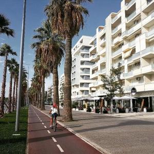 uma pessoa a andar de bicicleta numa rua ao lado de um edifício em Vlora Backpackers Hostel & Bar LUNGOMARE em Vlorë