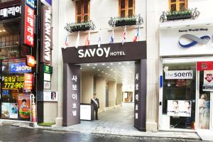 a man standing in front of a savoy hotel building at Savoy Hotel Myeongdong in Seoul