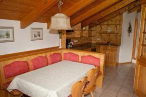 a bedroom with a bed and a kitchen with wooden ceilings at Kleinreiterhof in Bad Reichenhall