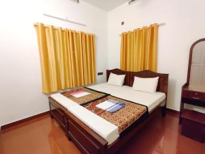 a bedroom with a bed with two pillows at Calvin's Inn in Cochin