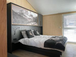 1 dormitorio con 1 cama con una foto en la pared en Villa Kreischberg, en Sankt Lorenzen ob Murau