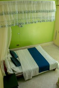 een klein bed in een kamer met een raam bij Seguku Katale Apartment 2 in Kampala