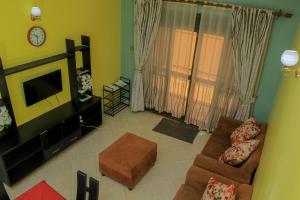 een woonkamer met een bank en een tv bij Seguku Katale Apartment 2 in Kampala