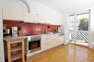 a kitchen with white cabinets and a large window at Marvellous Face in Bled