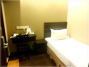 Habitación de hotel con cama y mesita de noche en GoodHope Hotel, Kelana Mall, en Petaling Jaya