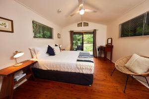 1 dormitorio con cama, escritorio y ventana en Cape Trib Farm en Cape Tribulation