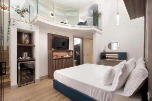 1 dormitorio con 1 cama y TV en la pared en Elys Suites en Sorrento