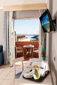 a living room with a table and a tv in a room at Bike&Boat Argentario Hotel in Porto Santo Stefano