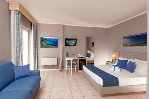 a hotel room with a bed and a couch at Bike&Boat Argentario Hotel in Porto Santo Stefano