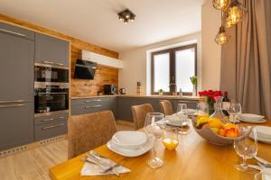 a kitchen and dining room with a table with a bowl of fruit at Chalets Gardenia in Donovaly