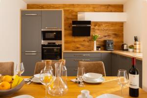 a kitchen with a wooden table with wine glasses at Chalets Gardenia in Donovaly