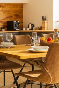 a wooden table with a bowl of fruit and wine glasses at Chalets Gardenia in Donovaly