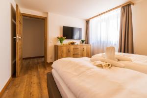a hotel room with two beds and a television at Chalets Gardenia in Donovaly