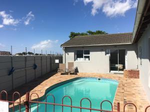 ein Swimmingpool im Hinterhof eines Hauses in der Unterkunft Pelican Accommodation Ottery in Kapstadt