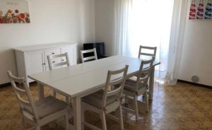 リド・ディ・イエゾロにあるRESIDENCE FARO - WALTERIGATO Apartments SOLO PER FAMIGLIEのダイニングルーム(椅子、白いテーブル付)