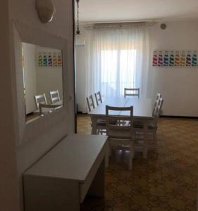 リド・ディ・イエゾロにあるRESIDENCE FARO - WALTERIGATO Apartments SOLO PER FAMIGLIEのダイニングルーム(テーブル、椅子、鏡付)