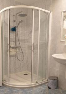 La salle de bains est pourvue d'une douche avec une porte en verre. dans l'établissement Santa Lina, à Ajaccio