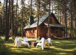grupa białych krzeseł przed kabiną w obiekcie Jarzębinowa - Dom do wynajęcia na Podlasiu w mieście Łuka