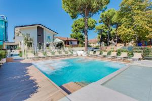 una piscina con sillas y una casa en Park Hotel Morigi Garden & Spa, en Gatteo a Mare