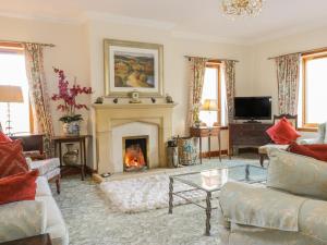 a living room with a fireplace and a tv at Torview House in Peebles