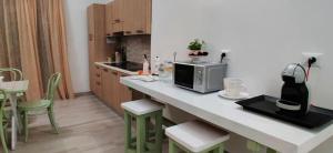 a kitchen with a counter with a microwave and chairs at Musa B&B in Taranto