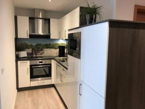 een keuken met witte kasten en een fornuis bij Steiner Strandappartements Appartement 307 Süd- Landseite in Stein +7 foto's