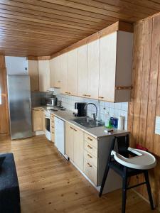 a kitchen with wooden cabinets and a sink and a chair at Lupiini in Savonlinna