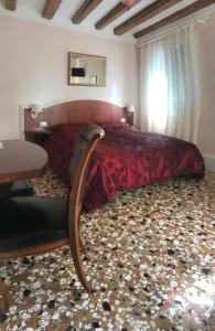 1 dormitorio con cama grande, mesa y ventana en B&B a le Boteghe en Venecia