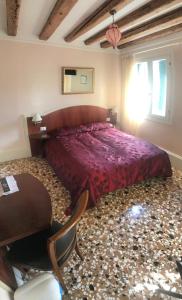 1 dormitorio con 1 cama grande, mesa y sillas en B&B a le Boteghe en Venecia