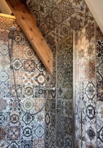 a bathroom with a shower with tiles on the wall at Royale Stadsloft in hartje Middelburg in Middelburg