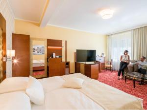 a woman is standing in a hotel room at Hotel Josefshof am Rathaus in Vienna