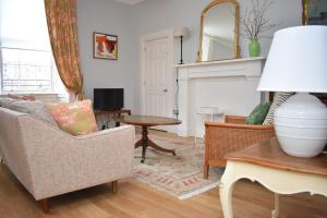 uma sala de estar com um sofá e uma mesa em Bernard St - Bright and spacious 1 bed apartment at the Shore! em Edinburgo