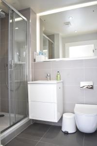 uma casa de banho com um chuveiro, um WC e um lavatório. em Bernard St - Bright and spacious 1 bed apartment at the Shore! em Edinburgo