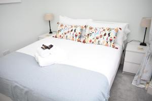a bedroom with a white bed with two pillows at Bernard St - Bright and spacious 1 bed apartment at the Shore! in Edinburgh