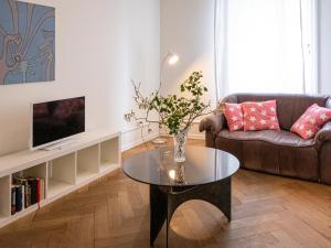 ein Wohnzimmer mit einem Sofa und einem Tisch in der Unterkunft Apartments Spalenring 10 in Basel