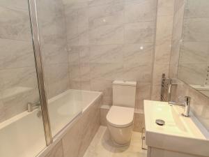 Un baño con inodoro, bañera y lavabo. en Harbourside Haven Penthouse 2, en Weymouth 8 fotos más