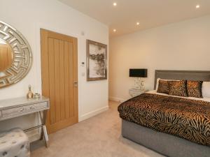 1 dormitorio con cama, escritorio y puerta en Harbourside Haven Penthouse 2, en Weymouth