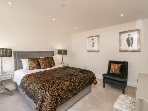 a bedroom with a king sized bed and a chair at Harbourside Haven Apartment 1 in Weymouth