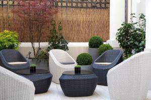 a patio with wicker chairs and a table at Hotel Berne Opera in Paris