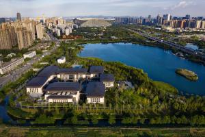 an aerial view of a building on a lake with a city at Gran Melia Chengdu in Chengdu