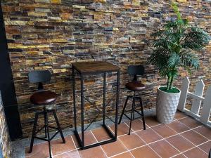 a couple of stools in front of a brick wall at Luxembourg Hills Homestay in Jiaoxi