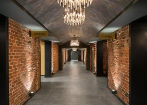 a hallway with brick walls and a chandelier at Hotel Kakola in Turku