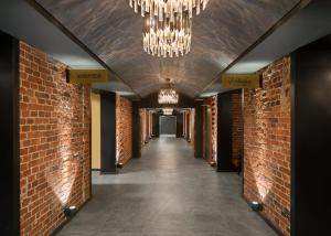 un couloir avec des murs en briques et un lustre dans l'établissement Hotel Kakola, à Turku